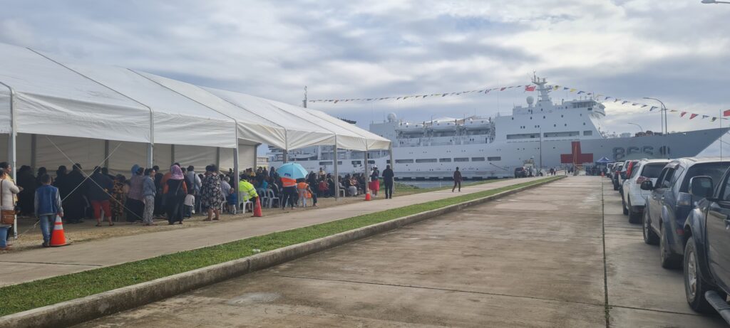 tongans waiting under a tent on the wharf waiting to board the peace ark to seek medical attention advice and treatment on wednesday morning 2nd august 2023
