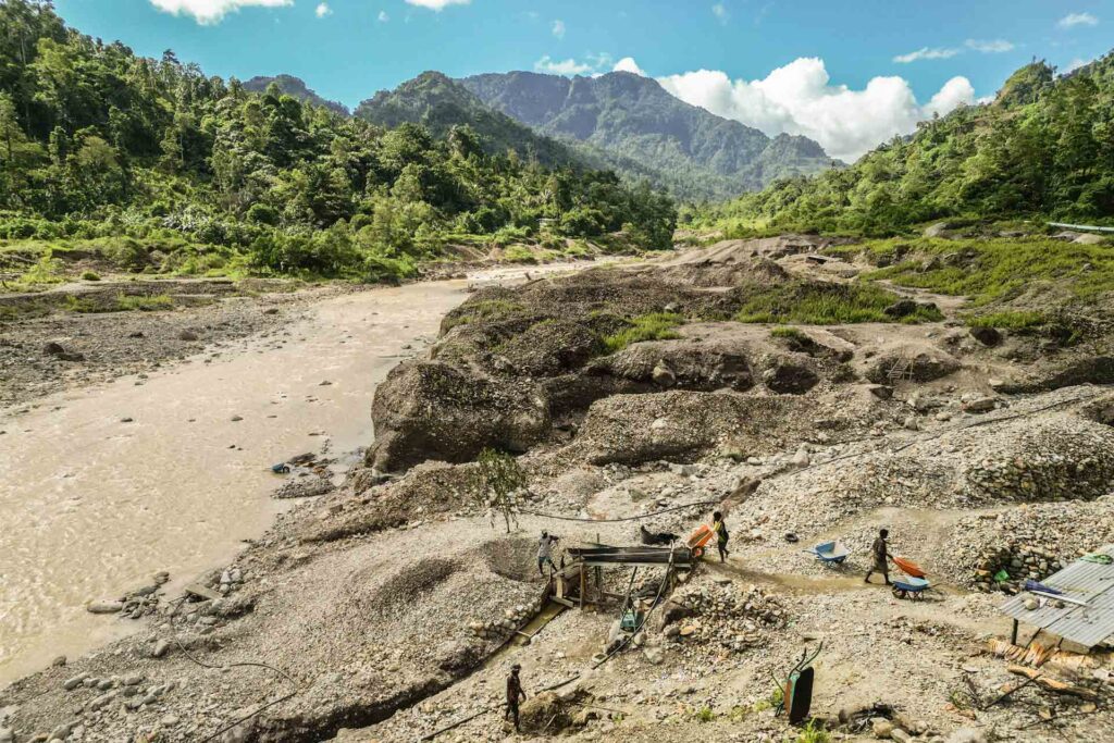 Artisanal miners search for gold in the waters downstream from the Panguna mine in Bougainville, Papua New Guinea. Photo - Aubrey Belford/OCCRP