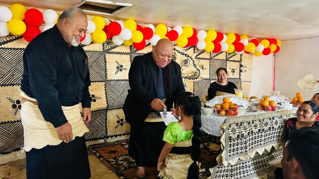 Lord Tu'iha'ateiho hands the keys to a new home owner's daughter on Tungua island. Photo - MOI