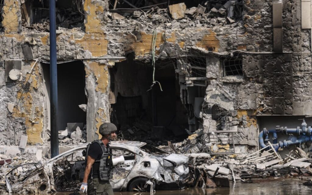 A member of the security forces walks past an Israeli police station in Sderot after it was damaged during battles to dislodge Hamas militants who were stationed inside, on 8 October 8, 2023. Photo: RONALDO SCHEMIDT / AFP